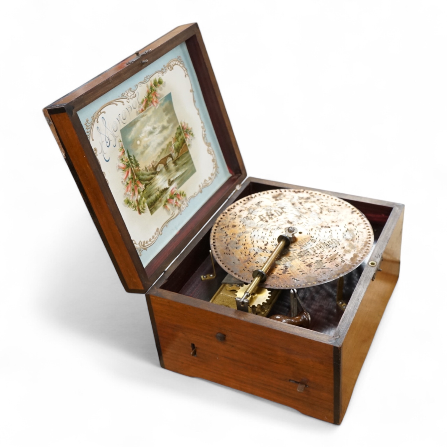 A late 19th century Monopol disc music box in a mahogany case, to play discs 19cm diameter, together with twelve discs, plus an ebonised ‘Chord-Harps’ zither in its original card box with tuning hammer.